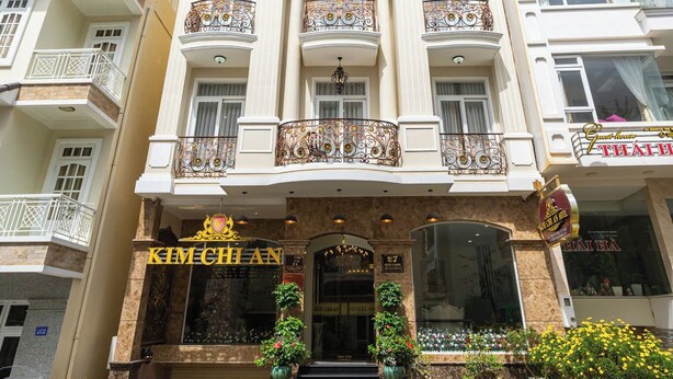 Un hotel de varios pisos con una entrada imponente, balcones y un letrero que dice "Kimchi An".