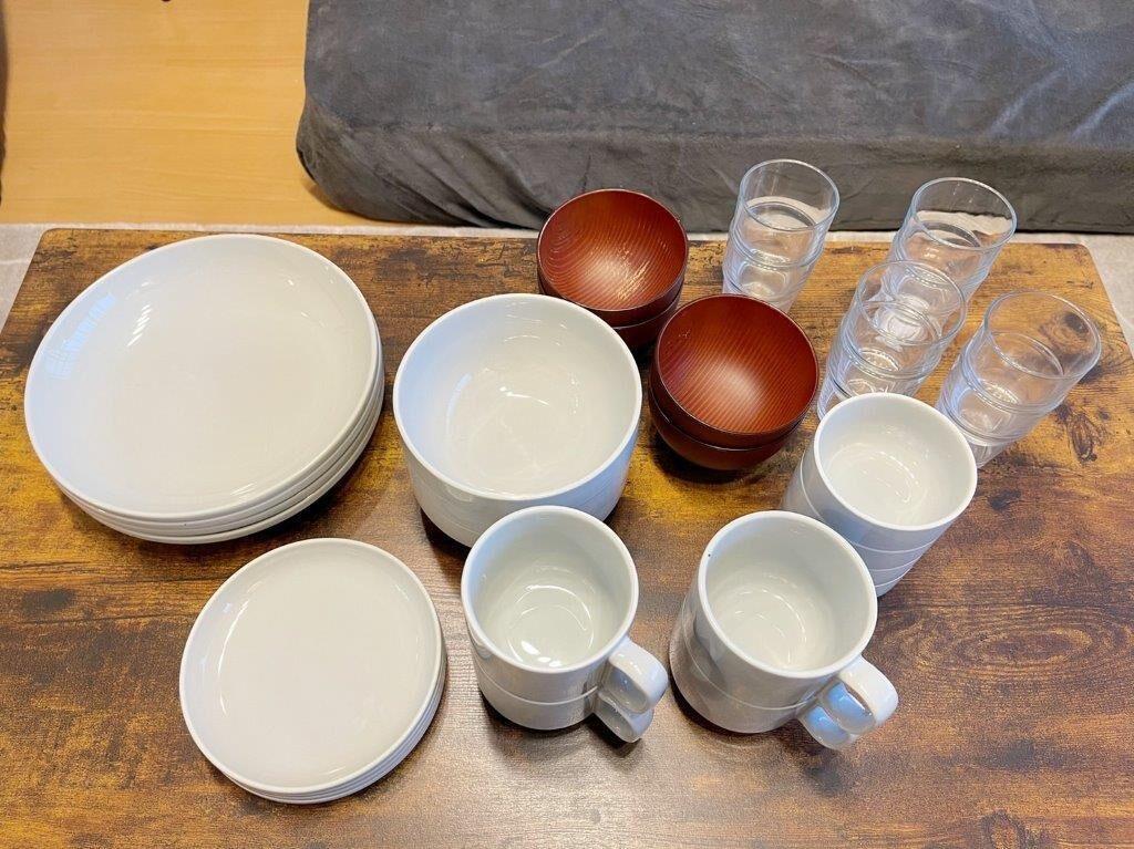 A table with various bowls and cups, some stacked and some placed.