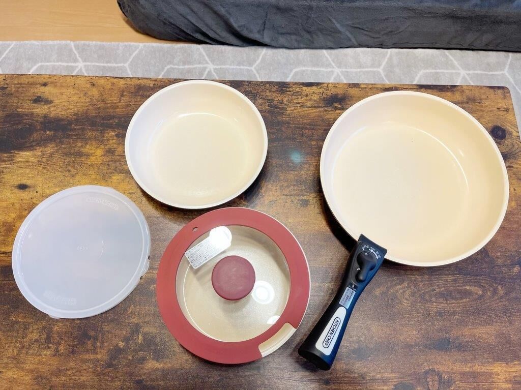 A wooden table with four bowls, a lid, and a pepper grinder.
