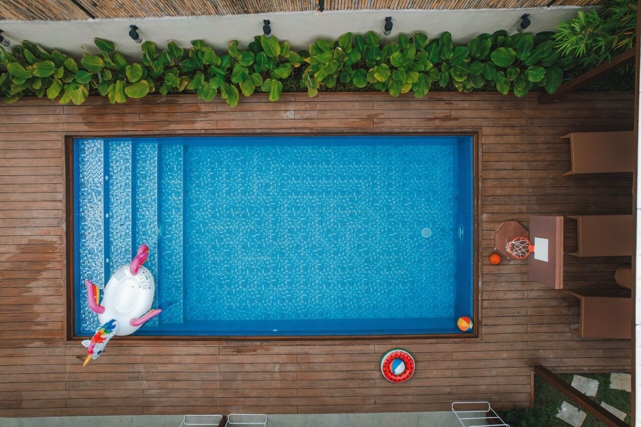 A rectangular swimming pool with a wooden deck surrounding it.
