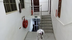 Una escalera con un carretel de manguera contra incendios y una señal de salida.