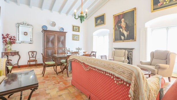 Amplio salón con techo alto, chimenea y comedor con muebles de madera.
