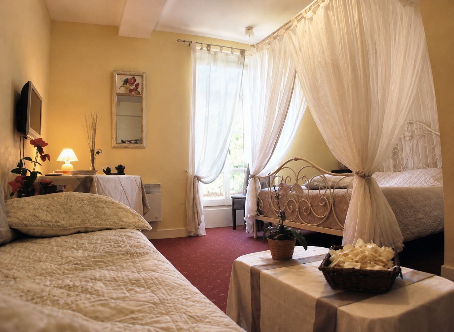 Une chambre avec deux lits, une table de chevet avec une lampe, un miroir et une fenêtre avec des rideaux.