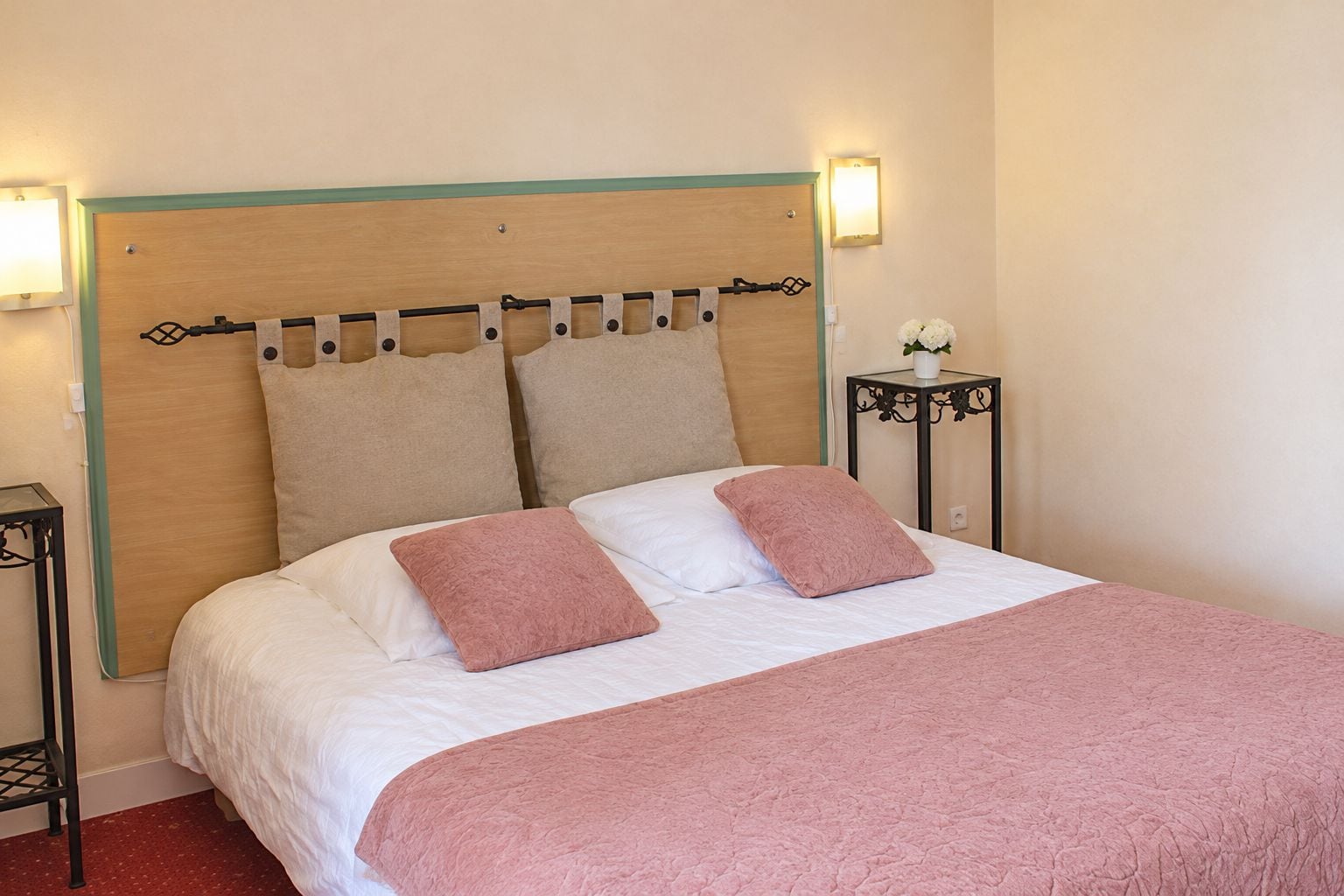 Een hotelkamer met een bed, twee nachtkastjes en een bijpassend nachtkastje met een lamp.