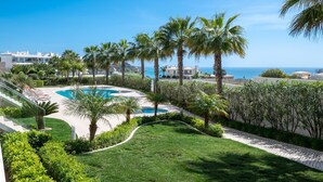 A pool surrounded by palm trees and a clear view of the ocean. - Villa Praia de Branson, with amazing Ocean views (Lagos)