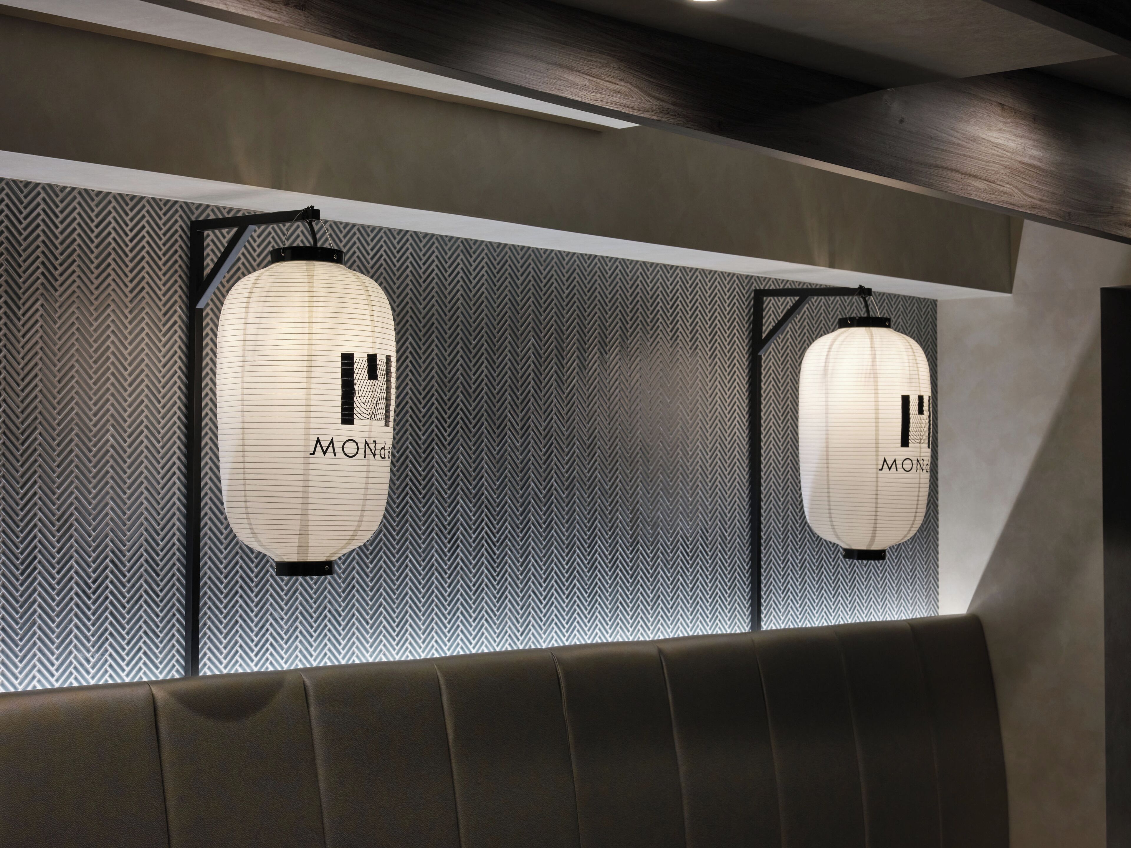 A modern interior with two hanging lanterns labeled "MONDO" against a patterned wall.