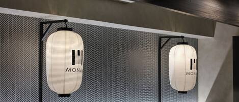 A modern interior with two hanging lanterns labeled "MONDO" against a patterned wall.