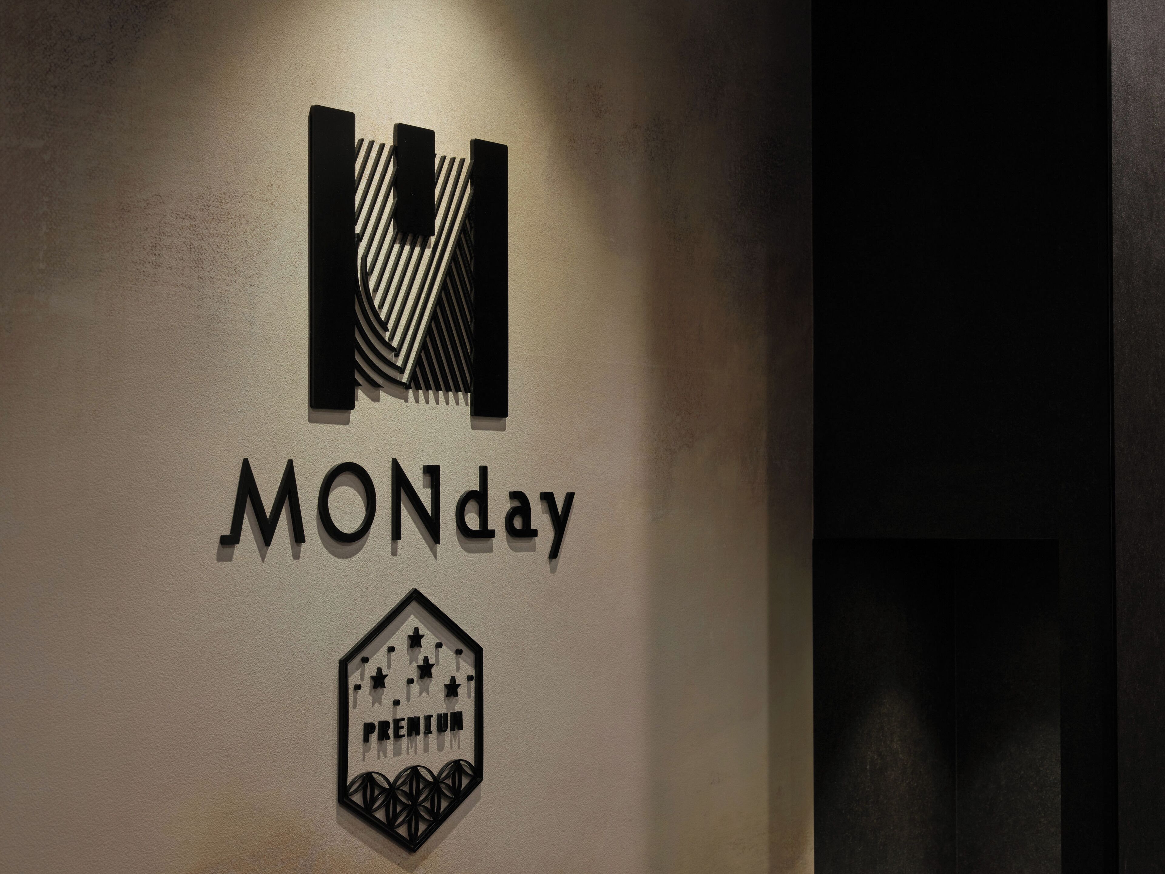 A wall with a logo and text reading "MONday" and "PREMIUM".