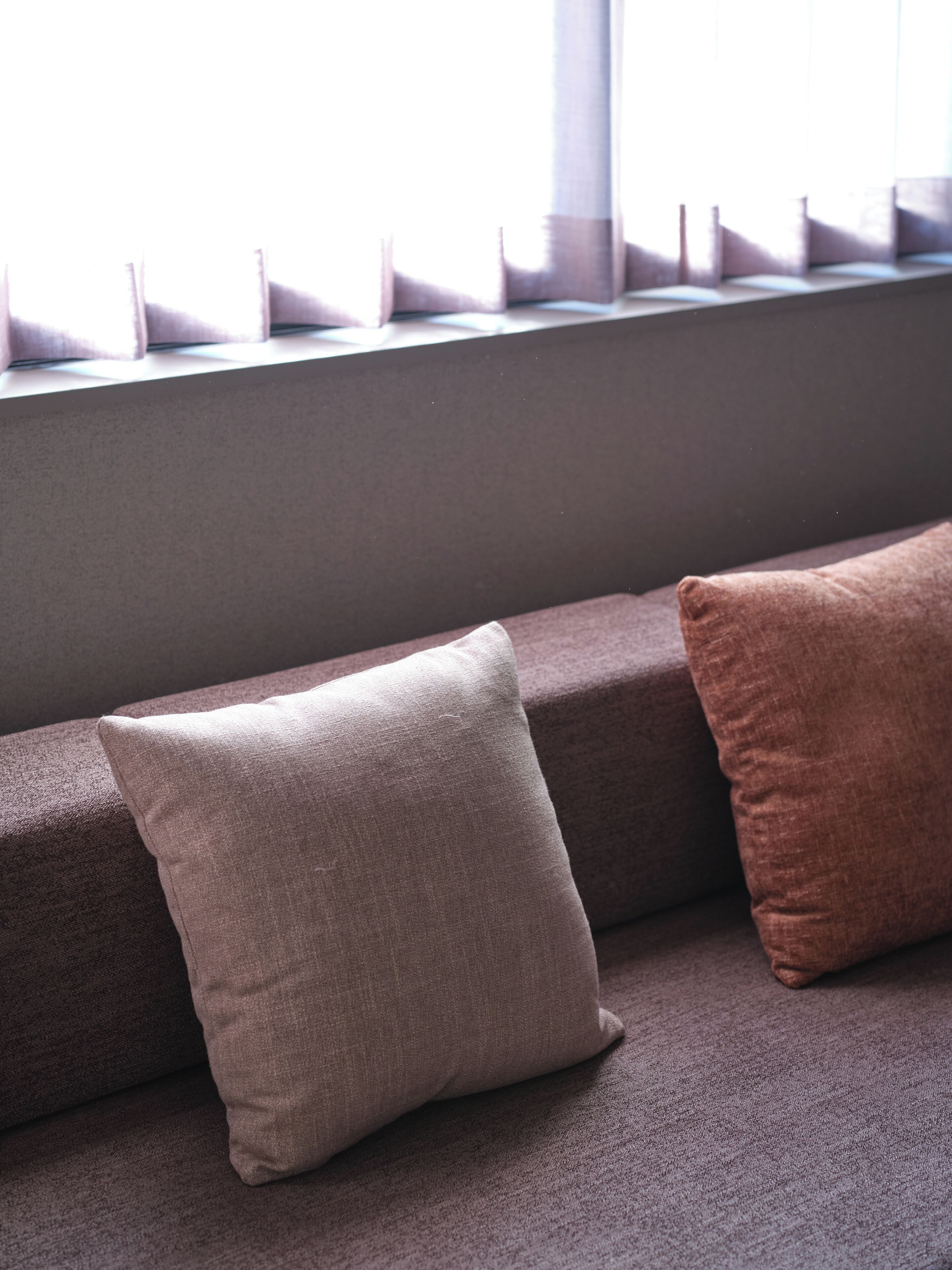 A seating area with a cushioned bench and two pillows.