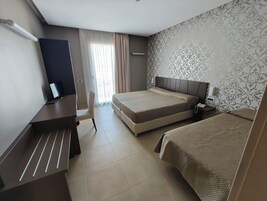 Camera tripla | Una cassaforte in camera, una scrivania, tende oscuranti