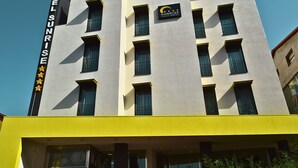 A modern hotel building with a sign reading "Sunrise Hotel" and a logo with a crescent moon and stars. - Sunrise Hotel (Casoria)