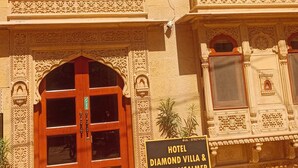 A building with ornate architectural details, including carved balconies and a large wooden door. A sign indicates it is the Hotel Diamond Villa & Safari Jaisalmer. - Hotel Diamond Villa Safari Jaisalmer  (Jaisalmer)
