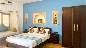 A bedroom with a bed, bedside tables, a wardrobe, and decorative mirrors. - Hotel Diamond Villa Safari Jaisalmer  (Jaisalmer)