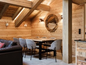 Un intérieur en bois comprenant une table à manger, des chaises, un canapé et un miroir.