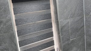 Une salle de bain avec une cabine de douche, des murs carrelés et des toilettes.