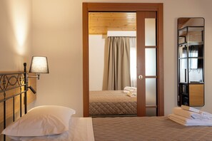 A hotel room with a bed, a bedside lamp, a wooden door, and a mirror on the wall. - VILLA CHIARA (Gradara)