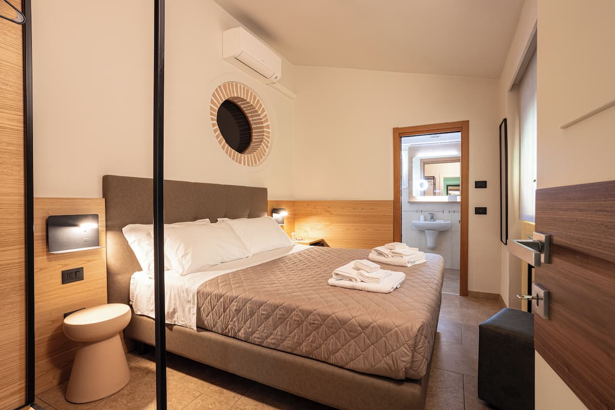 Deluxe Triple Room, Garden View | Minibar, in-room safe, blackout drapes, soundproofing