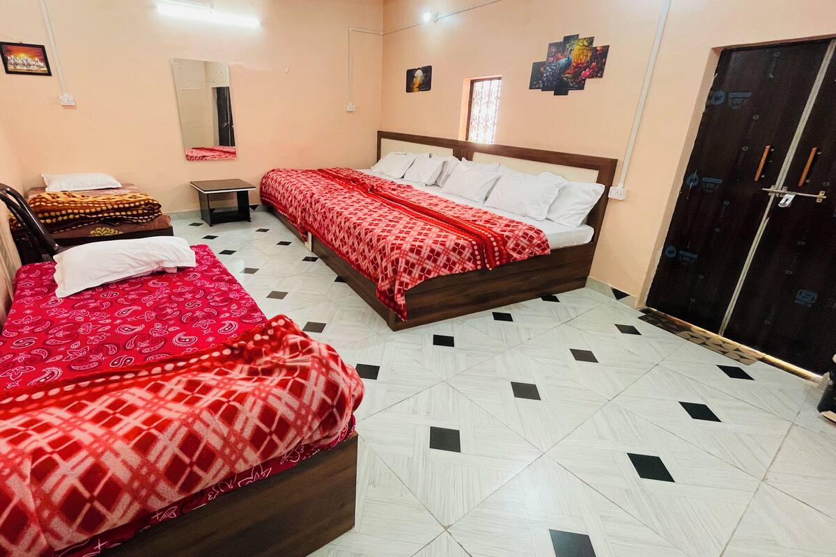 Une chambre avec deux lits, une armoire, un miroir et une petite table.