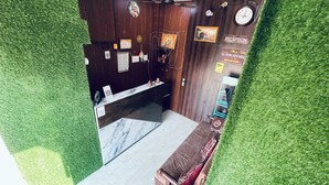 Un espace d’accueil avec un comptoir en marbre, des murs en bois, une horloge et un panneau indiquant « Réception ».