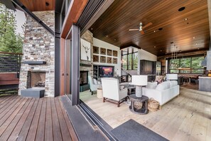 A spacious living area with a stone fireplace, modern furniture, and a large TV. - Martis Camp Luxury Monthly Rental 4 BR 4.5 BA, Hot Tub (Truckee)