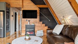 Una sala de estar moderna con chimenea, un sofá de cuero marrón y una mesa de centro de mármol.