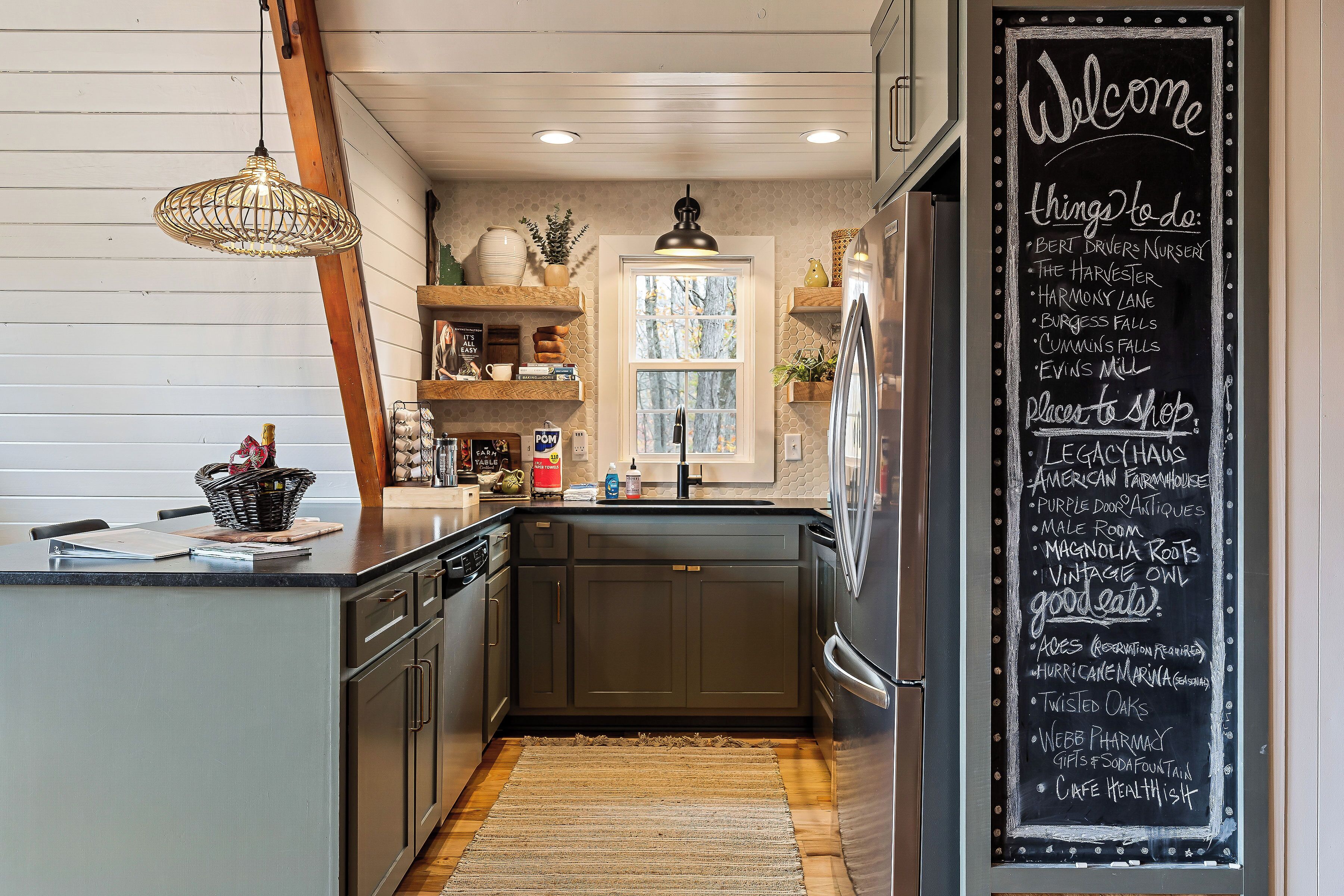 A kitchen with a chalkboard listing local attractions and shops.