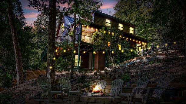 A cabin with a fire pit and outdoor seating, surrounded by trees and a wooden deck. - New Listing! Mtn Cabin: Fire pit, Hot tub Views (Cherry Log)
