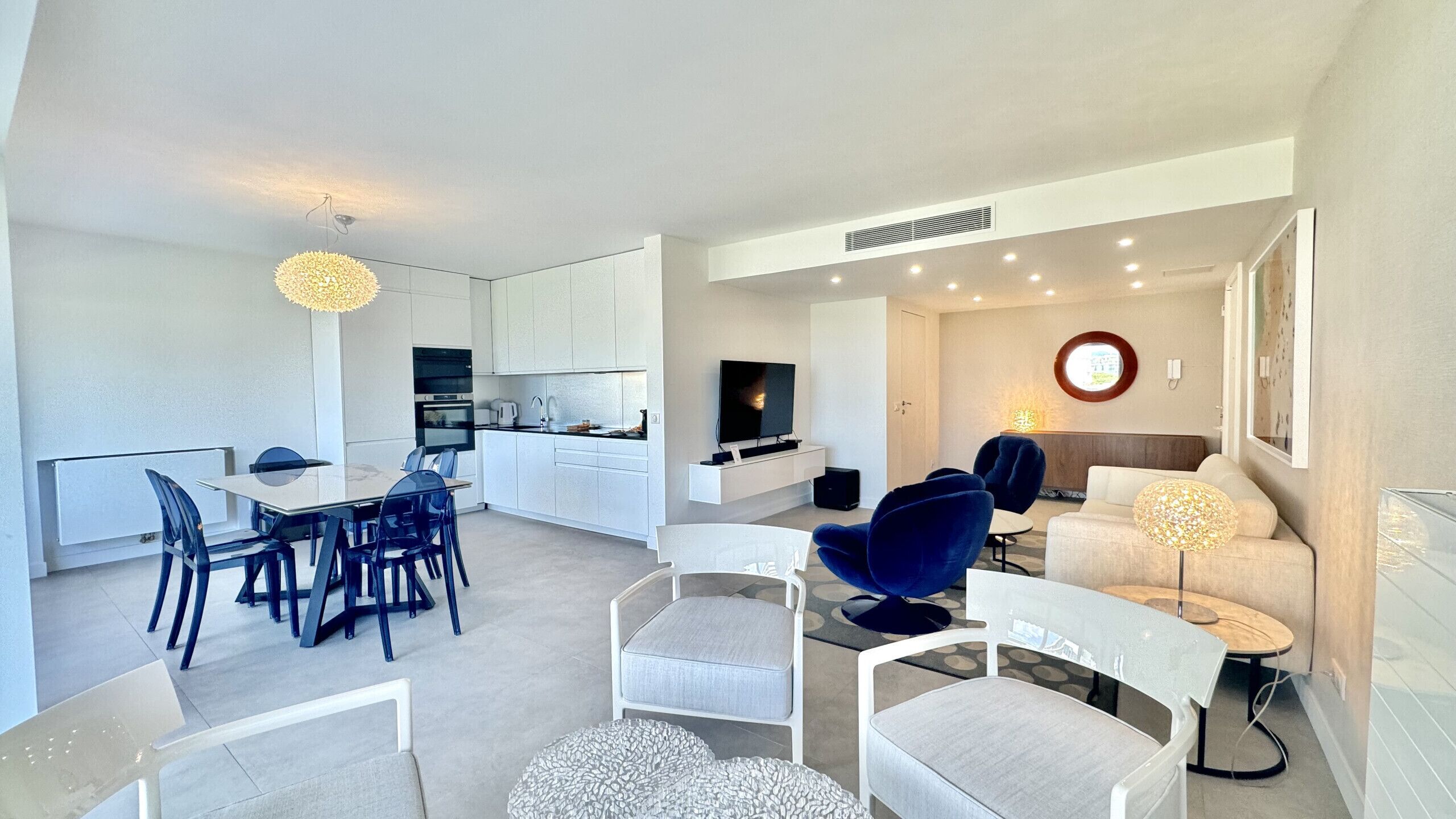 Eine moderne Wohnung mit Essbereich, Küche, Wohnzimmer und einem kleinen Balkon.