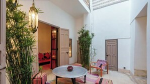 A cozy indoor space with a round table, cushioned seating, and decorative plants. - Exclusive charming riad in the heart of the medina

10 mn from Jemaa el fna  (Marrakech)