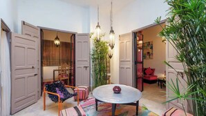 An open-plan living area with a round table, chairs, and a hanging light fixture. - Exclusive charming riad in the heart of the medina

10 mn from Jemaa el fna  (Marrakech)