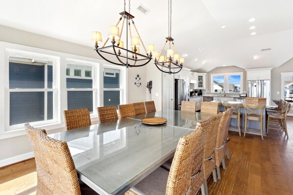 A spacious kitchen with a large island, white cabinetry, and a view to the outside.