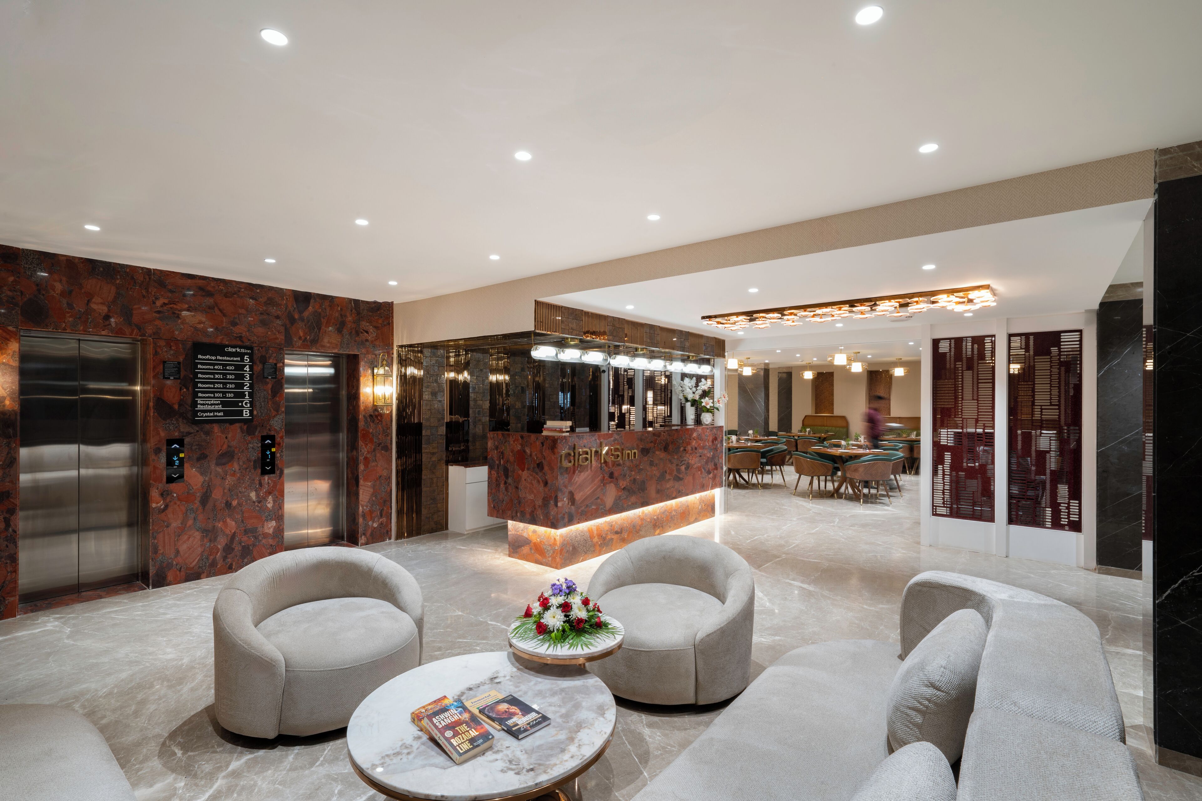 A modern lobby with marble flooring, a reception desk, two sofas, and a coffee table.