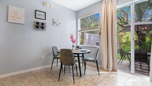 A dining area with a round table, chairs, and a window with a view of greenery. - Family escape near Disney parks w/ resort access (Kissimmee)
