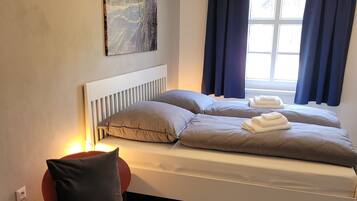 Ein modernes Schlafzimmer mit einem Bett, einem kleinen Tisch und einem Sessel.