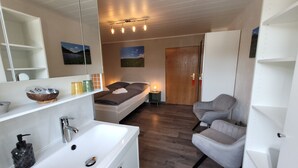 A modern bathroom with a large white sink, a mirror, and a wooden floor. - VINEU - Bed n Breakfast (Winterberg)