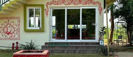 A building with a staircase, a large glass door, and a red decorative border.