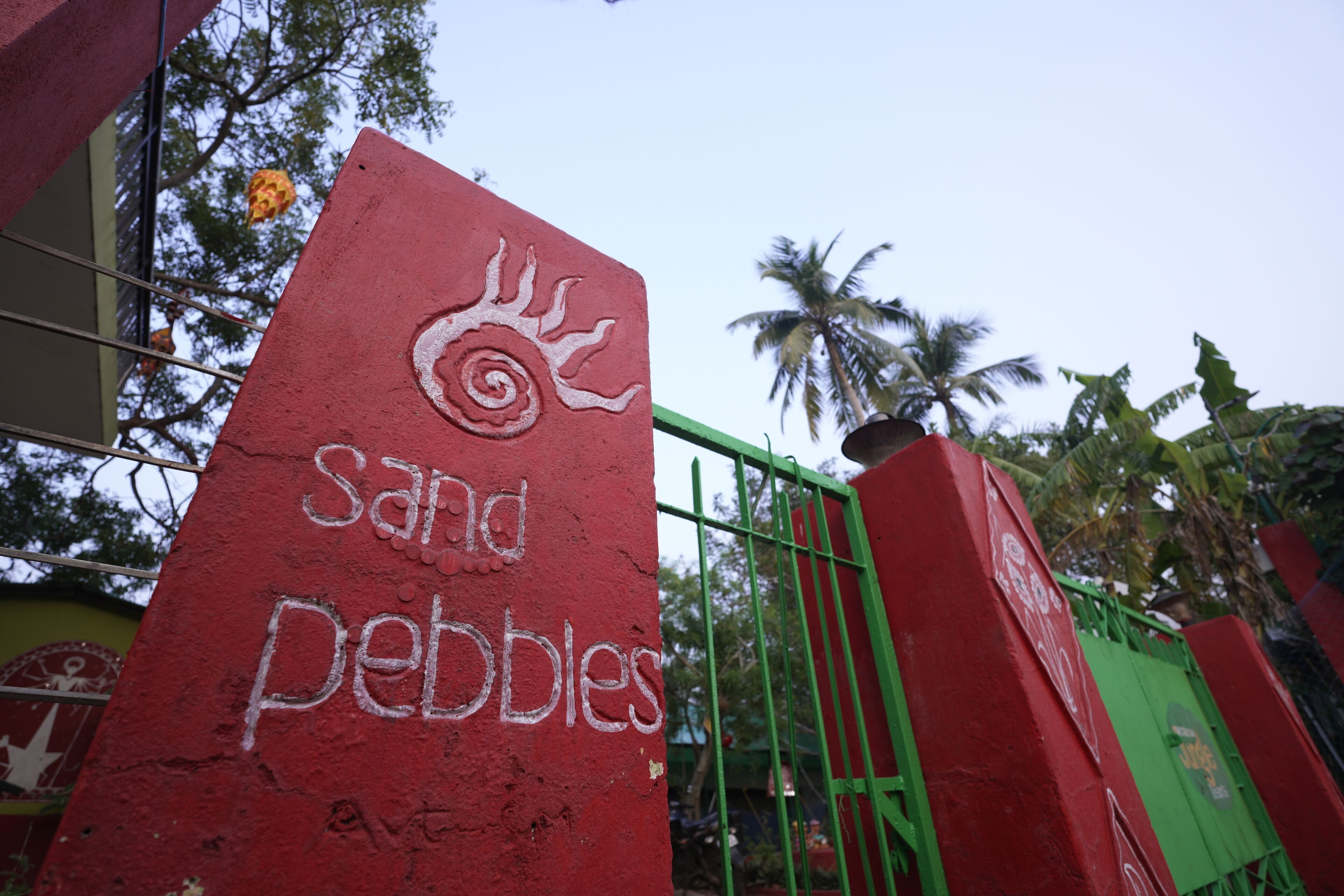 A red pillar with the words "sand pebbles" and a sun design.