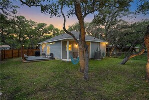 A single-story house with a porch, a hammock, and a small deck area.