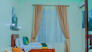 Ein modernes Schlafzimmer mit einem Bett, einem weißen Sofa, einem Holztisch und einem Deckenventilator.
