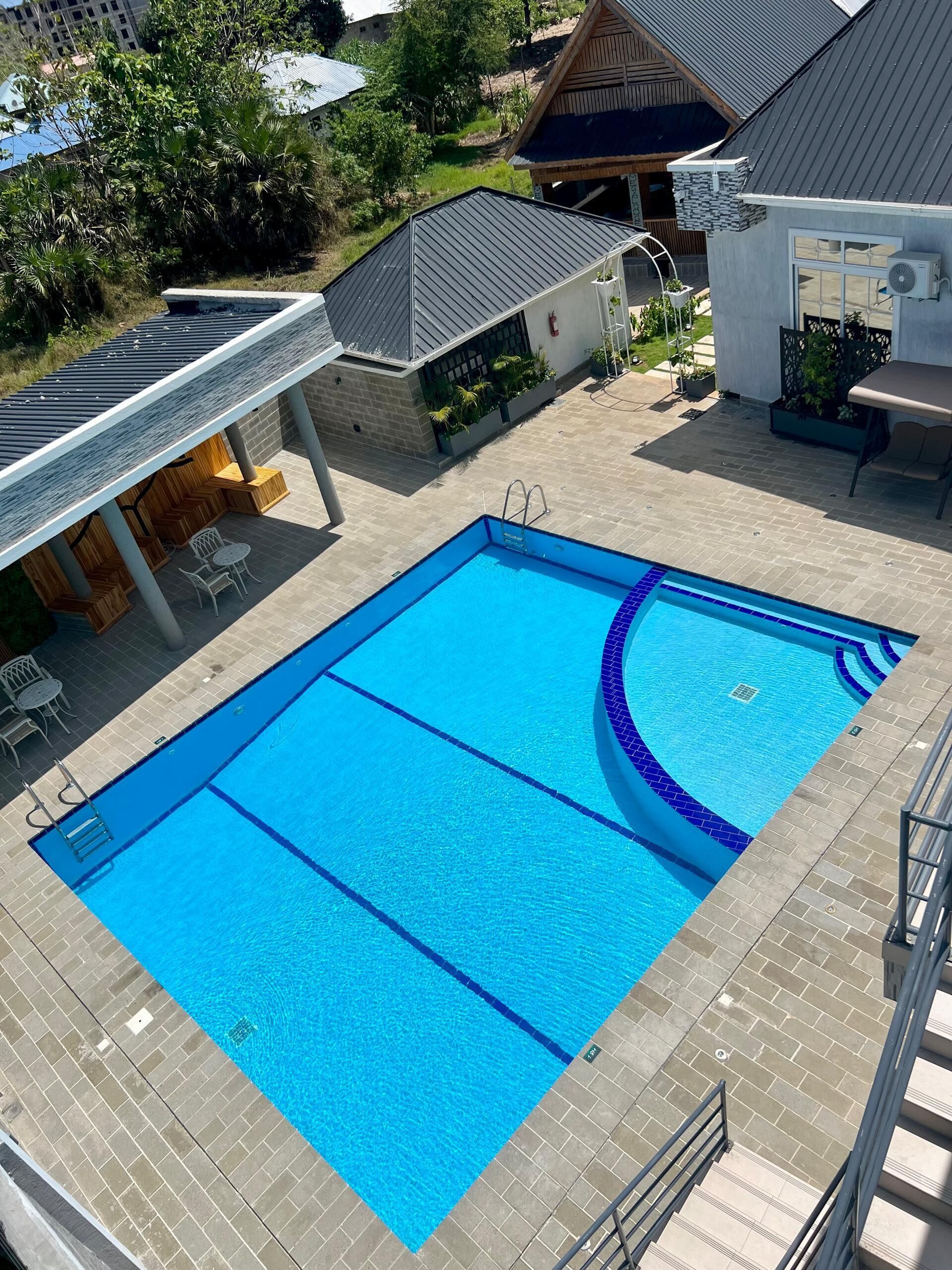 Utomhuspool, solstolar och livvakter på plats