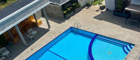 Utomhuspool, solstolar och livvakter på plats