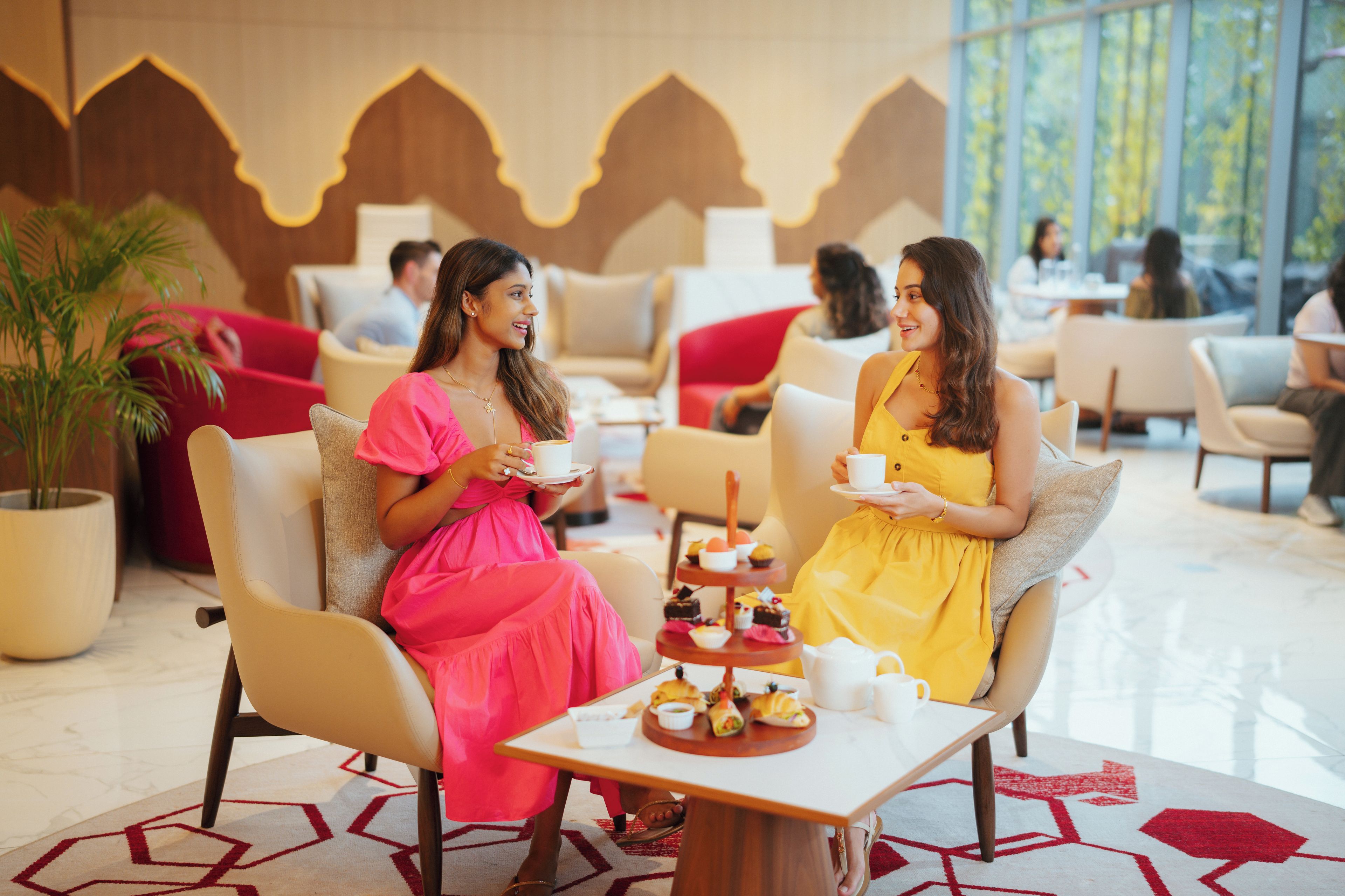 A lobby area with seating arrangements and a table with a variety of pastries.