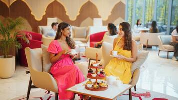 A lobby area with seating arrangements and a table with a variety of pastries.