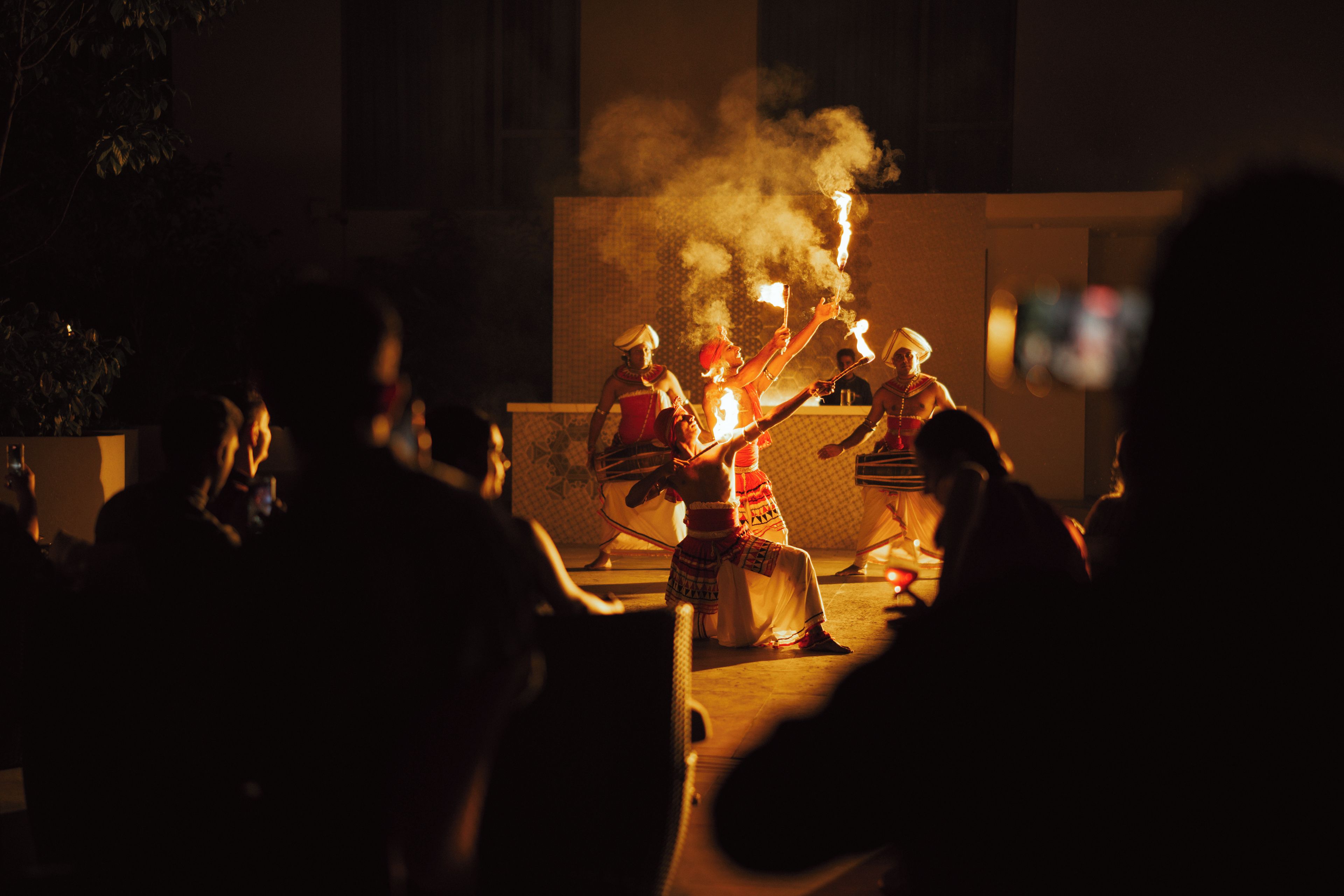 A group of people performing a fire ritual outdoors at night.