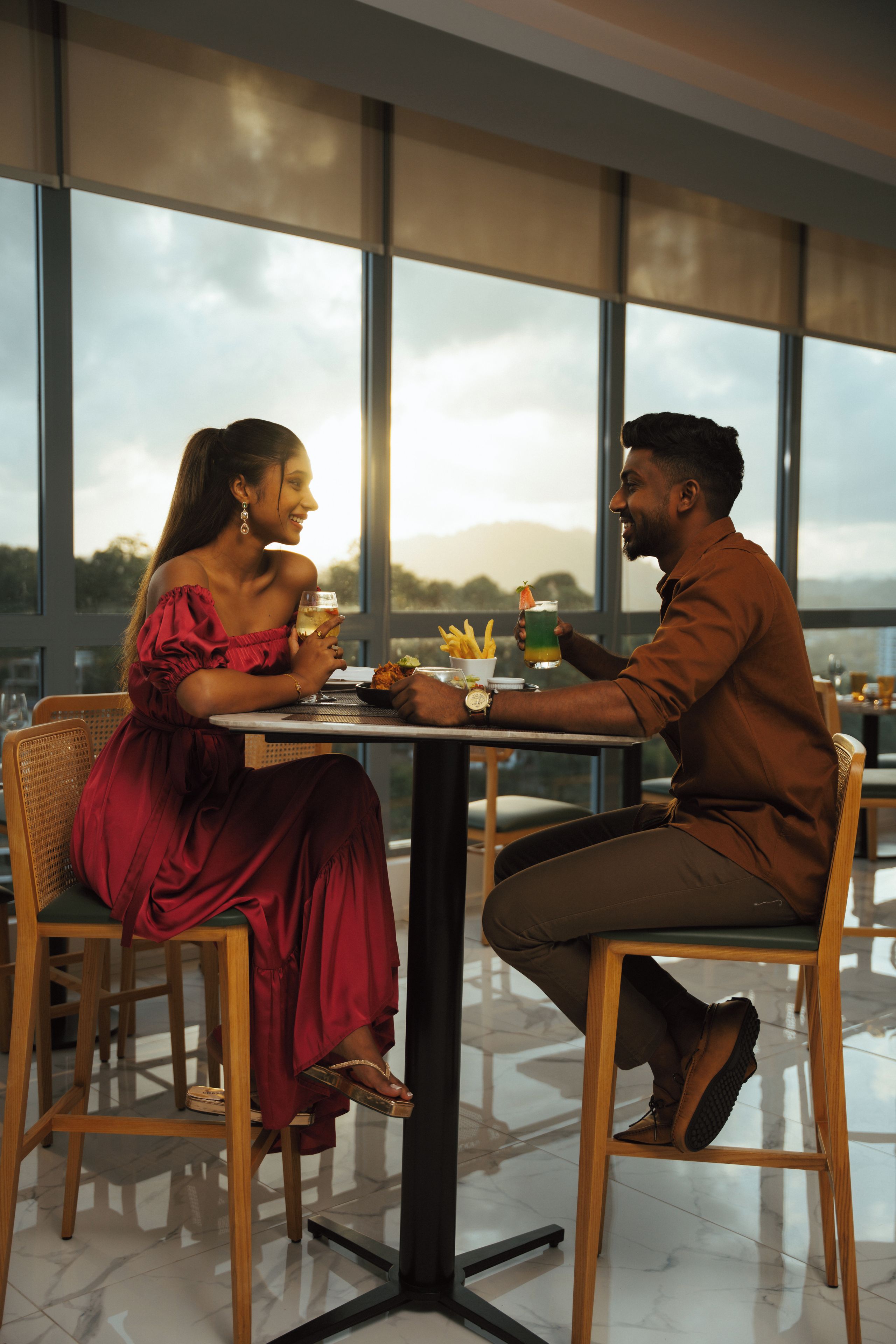 A couple dining at a table with a view of the outdoors.