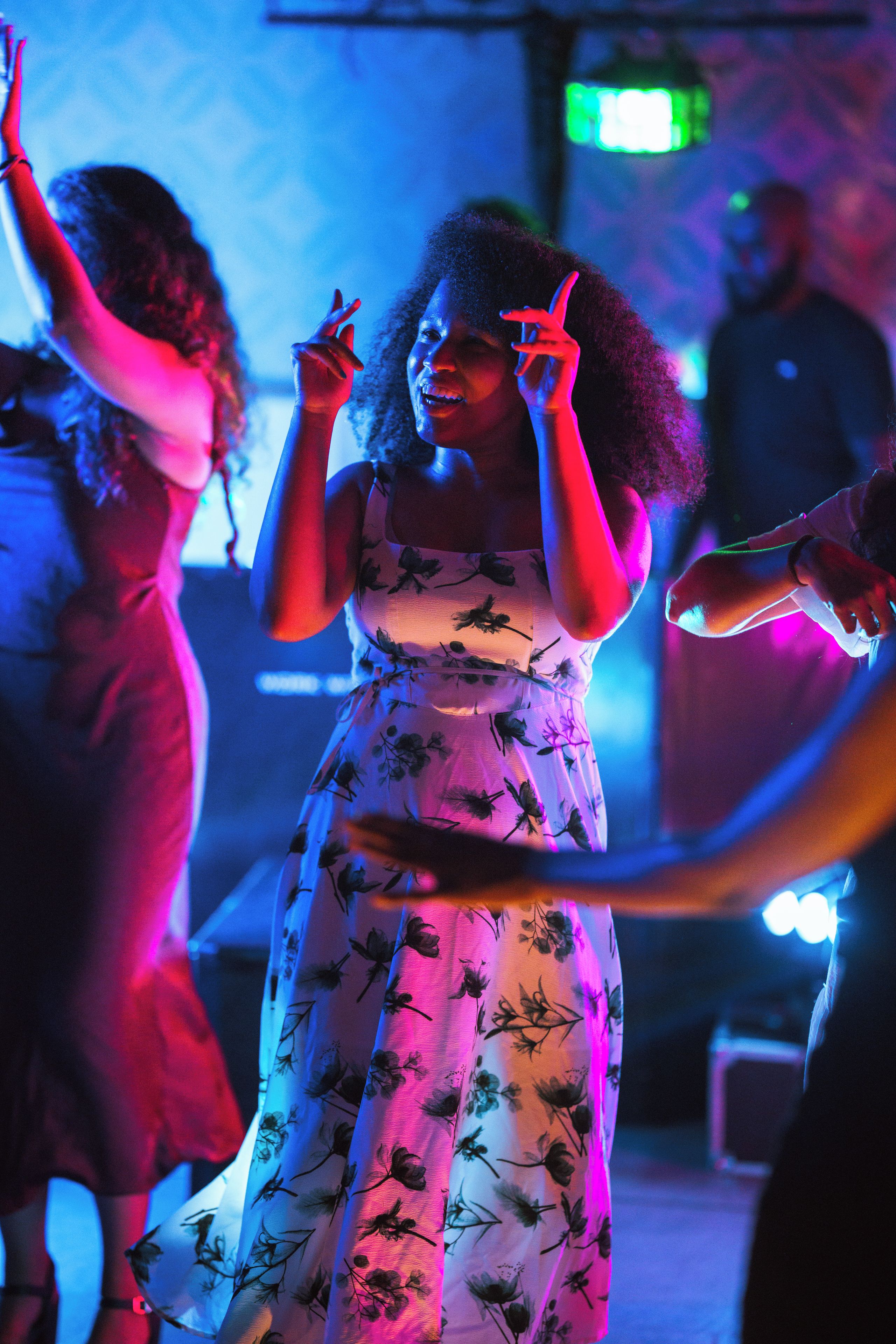 Una persona con un vestido floral bailando en un evento social.