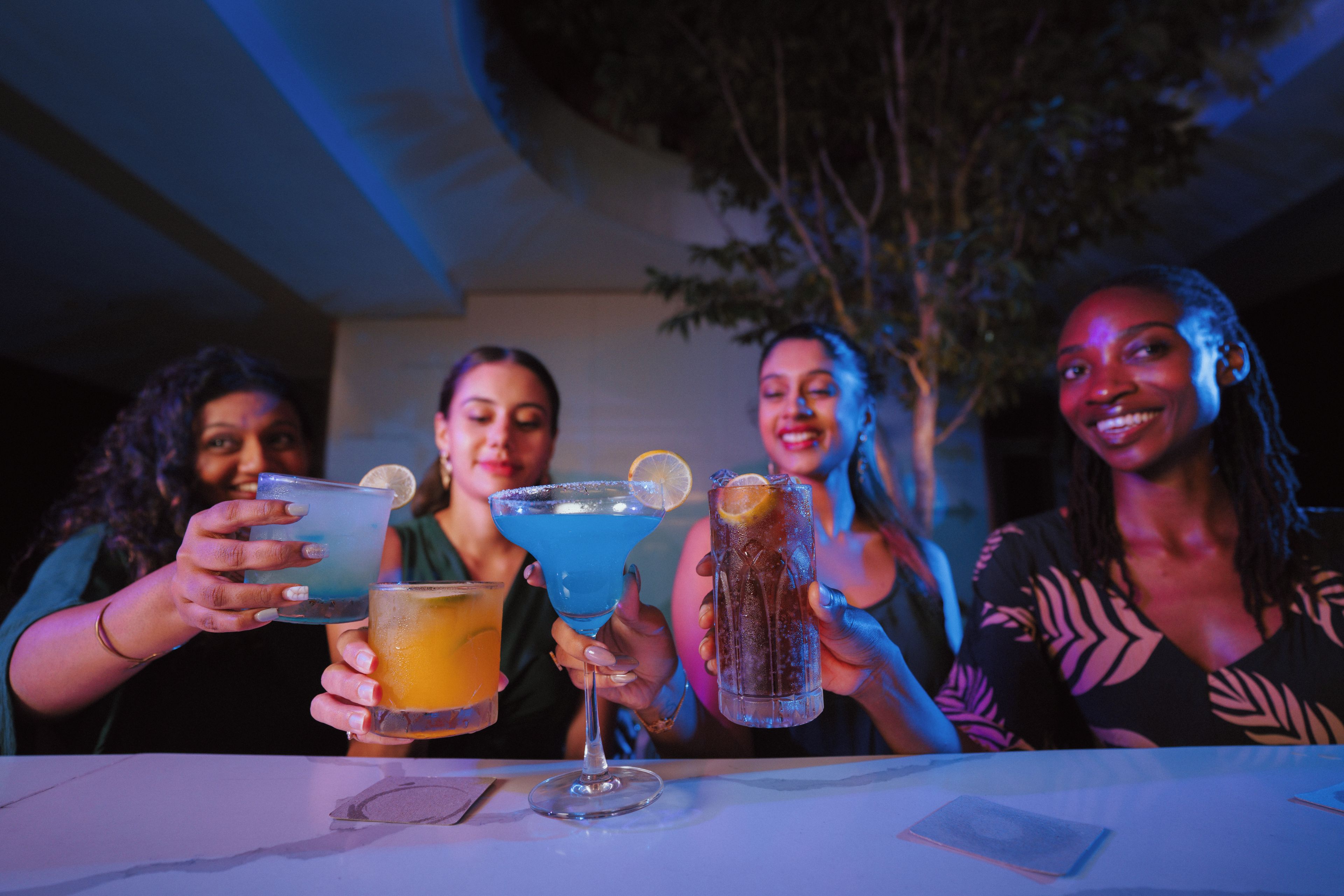 Un grupo de personas sosteniendo bebidas en una mesa.