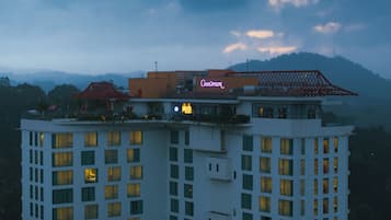 Un hôtel à plusieurs étages, reconnaissable à son grand panneau lumineux au néon sur le toit.