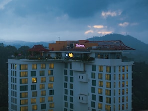 Un hôtel à plusieurs étages, reconnaissable à son grand panneau lumineux au néon sur le toit.