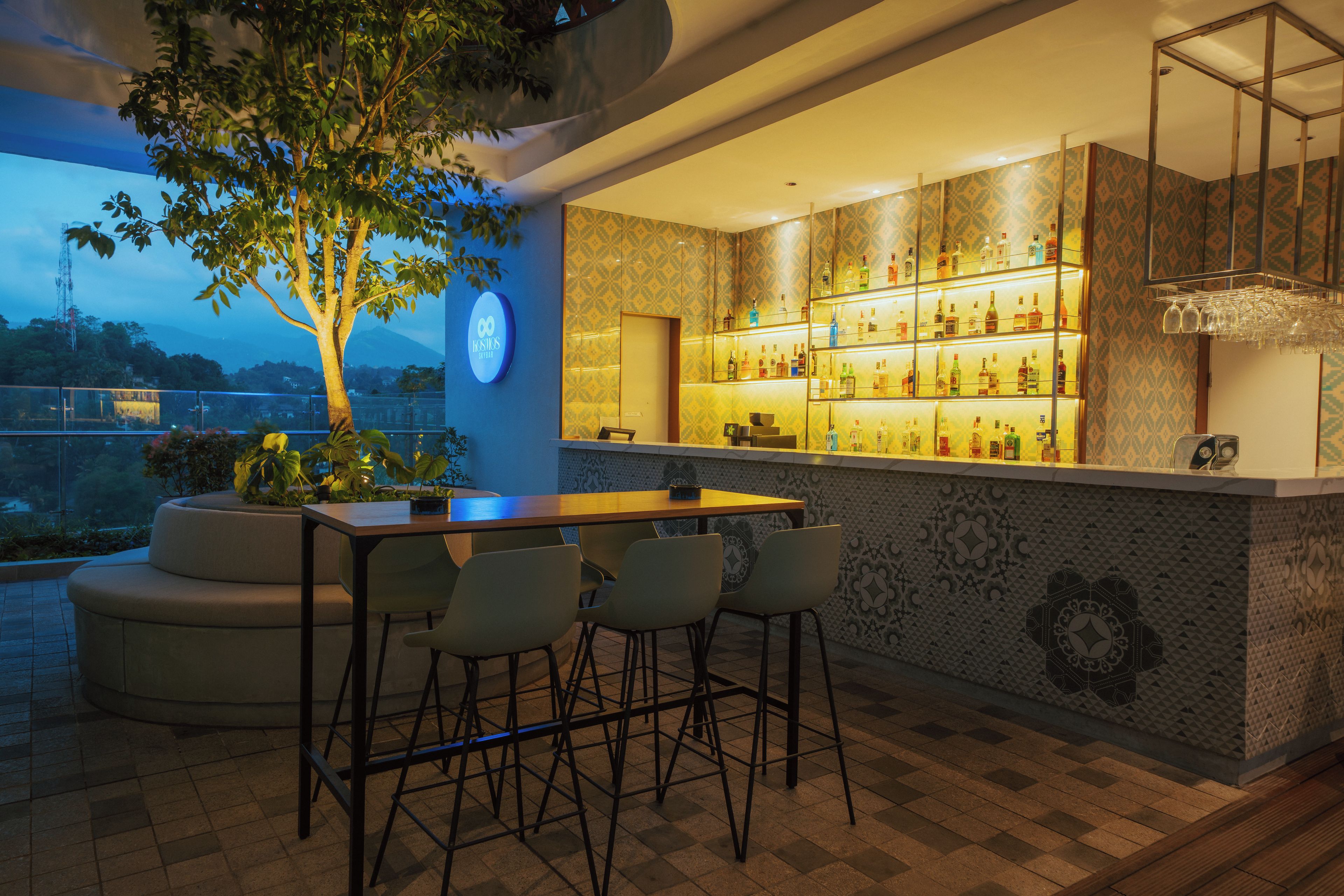 A bar area with a seating arrangement and a view of the outdoors.
